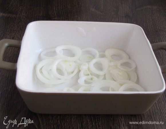 Форму смазать растительным маслом и выложить колечки лука.