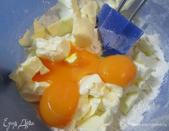 Добавить желтки и размягчённое сливочное масло.