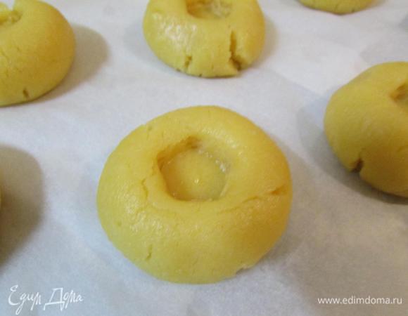 Из каждого кусочка скатать шарик и сделать углубление. Выложить печенье на противень, покрытый бумагой для выпечки. Оправить в разогретую духовку (180°С) и выпекать 15-20 минут. 