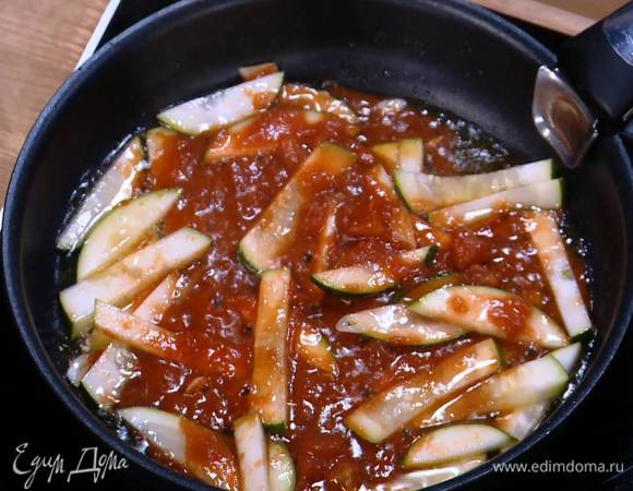 Разогреть в сковороде 1 ст. ложку оливкового масла, выложить чеснок и цукини, добавить помидоры в собственном соку и все обжарить.