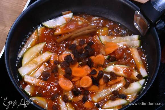 В сковороду с цукини добавить морковь, палочку корицы и изюм, посыпать паприкой и солью, все перемешать и еще немного обжарить.