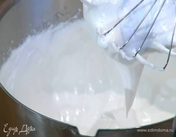 Белки взбить в комбайне в воздушную массу, затем, не выключая комбайна, добавить половину зерен ванили и по ложке всыпать сахар, взбивая после каждой порции по 5–10 секунд. Влить уксус и взбивать еще не менее 5 минут.