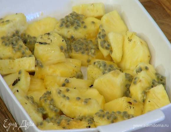 Плоды маракуйи разрезать пополам, вынуть ложкой мякоть и выложить на ананас, сверху поместить оставшиеся зерна ванили.