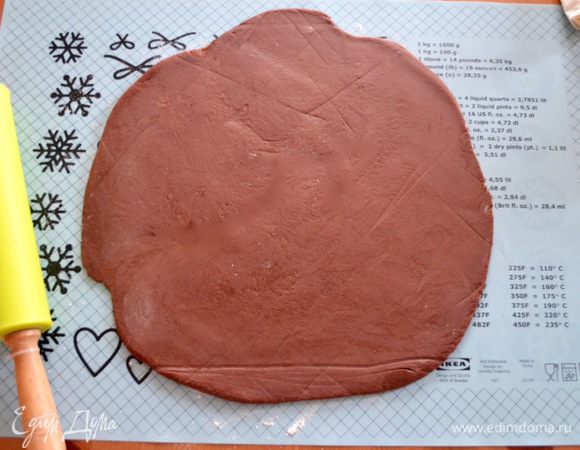 Подошедшее тесто выложить на рабочую поверхность и раскатать в круг диаметром примерно такого же размера, как и диск готового слоеного теста. Обильно смазать поверхность шоколадного теста растопленным сливочным маслом и присыпать сахаром.