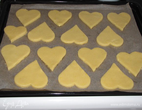 Соединить сухую часть теста с масляно-яичной, замесить тесто. Тесто мягкое и эластичное, хорошо собирается в шар. Убрать тесто на полчаса в холодильник. Раскатать в круг, толщиной 7 мм. и вырезать формочкой сердечки, или что-то другое. Оставшееся тесто снова собрать в шар и снова раскатать, вырезать сердечки и т. д. пока все тесто не закончится. Выложить на противень застеленный пекарской бумагой. Выпекать в разогретой до 180°C духовке 15 минут до легкого зарумянивания.