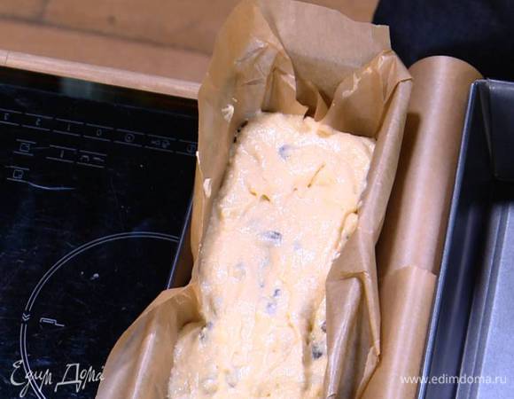 Продолговатую форму выстелить бумагой для выпечки, выложить тесто и разровнять его.