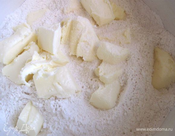 Муку с солью смешать с охлажденным маслом, порезанным на кусочки. Добавить холодное вино, перемешать до однородности.  
