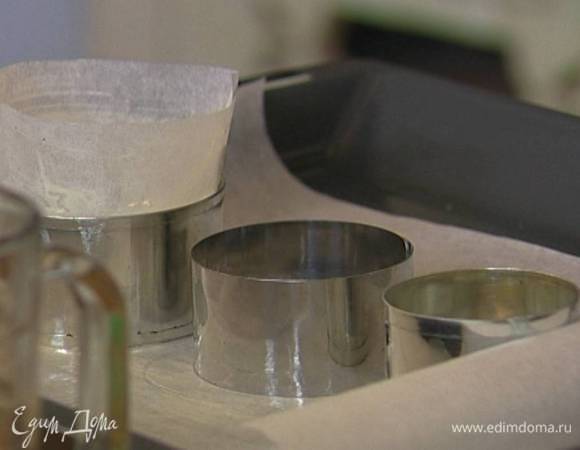 Выстелить противень бумагой для выпечки, смазать ее сливочным маслом, поставить на нее кольца для выпечки и выстелить их изнутри бумагой для выпечки, смазанной сливочным маслом. 