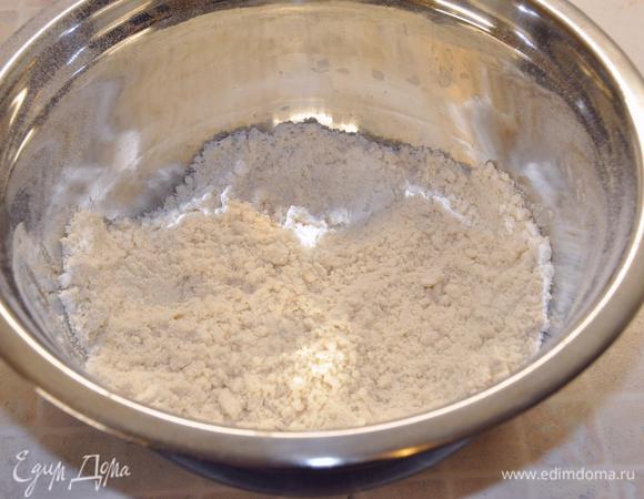 Включить разогреваться духовку до 180°C.
В миску налить растительное масло, просеять туда перемешанную с разрыхлителем и солью муку. Растереть до мелкой крошки. 