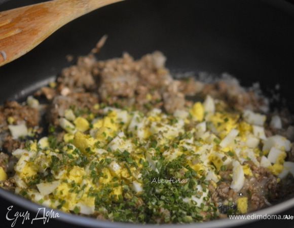 Приготовим начинку. Яйца отварить, очистить и мелко порубить.
В тефлоновой сковороде разогреть оливковое масло на среднем огне. Добавить лук и порубленные грибы. Обжарить до готовности 10 минут. Добавить мелко порезанное яйцо, зелень и сливочное масло. Посолить и поперчить по вкусу. Дать остыть.