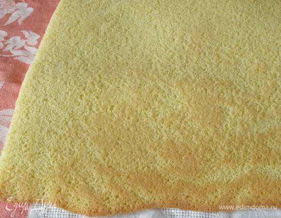 Распределяем тесто на пергаменте, смазанном маслом, выпекаем при 180°C 12-15 минут. Переносим бисквит на полотенце и снимаем пергамент.