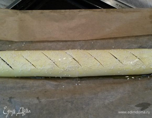 Разогреваем духовку до 180°C. 
Смазываем рулет остатками яичной смазки, хлебным ножом делаем надрезы, посыпаем кунжутными семечками. 
Выпекаем 30-35 минут.
Приятного аппетита!
