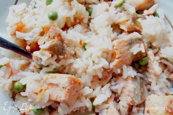 Смешать рис с горошком, добавить рыбу вместе с соком, который образовался при тушении и аккуратно перемешать. Зелень добавить по вкусу .