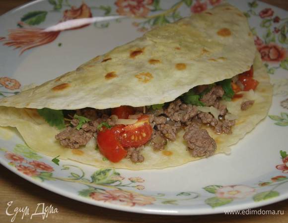 На одну половину каждой тортильи выложить начинку, посыпать кинзой и накрыть второй половиной лепешки.