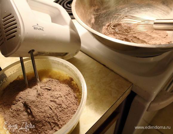 Взять половину просеяной сухой смеси, всыпать в мясляно-сахарно-яичную смесь и хорошо размешать.