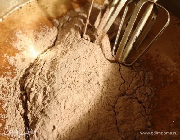 Затем всыпаем вторую половину сухой смеси, размешиваем тесто. Оно получается очень жидким и его получается немало.
Я разделила на две части и пекла в форме 26 см. Каждый бисквит пекся около 40 минут — нужно проверять шпажкой или зубочисткой. Ибо из-за шоколадного цвета на степень готовности визуально не угадаешь.