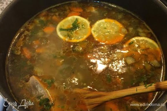 Добавить оливки и каперсы. Зелень мелко нарезать. Зелень и лимон добавить в суп. Посолить, поперчить и снять с огня.