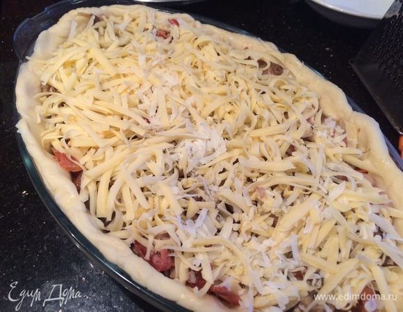 Посыпьте тертым твердым сыром, выпекайте в духовке 30 минут, затем уменьшите температуру до 160°C.