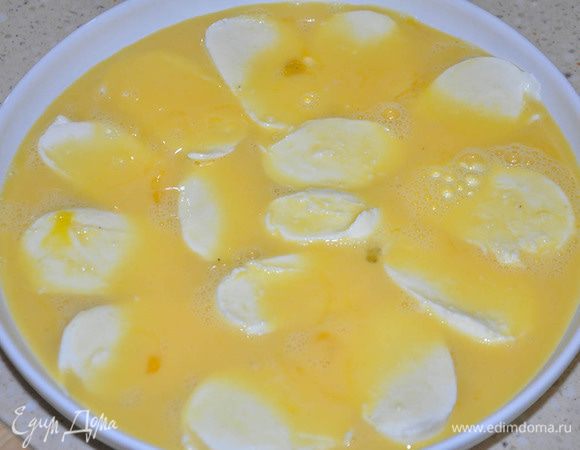 Моцареллу (у меня было 2 средних шарика) нарезать толстыми ломтиками. Выложить на блюдо. Взбить слегка вилкой яйца с молоком и солью. Залить моцареллу.