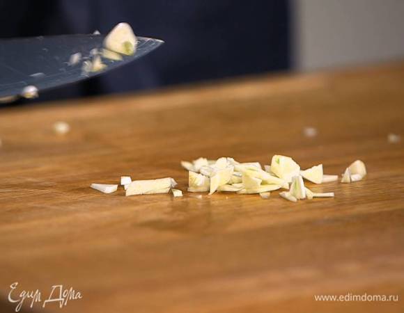 Чеснок почистить, мелко порубить, добавить в сковороду с луком и обжарить все вместе до слегка золотистого цвета.