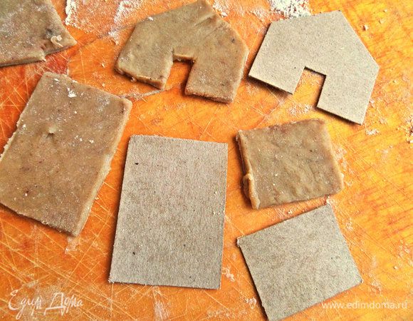 Но сегодня выкраиваем домики! Для этого из картона вырезать заготовки-выкройки: 2 прямоугольника 5х3,5 см, 2-3,5 см на 2,7 см и 2 профиля с дверным отверстием 5х2,7 см со скосом крыши 3 см с каждой стороны. Наложить картонный шаблон на раскатанное тонкое тесто, провести ножом по краю и вынуть аккуратно заготовки.