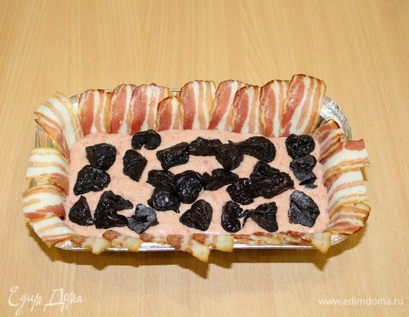 Выложить половину мясной массы в форму, распределить чернослив.