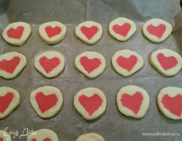 Духовку разогреваем до 200°С. 
Еще раз покатаем рулет по столешнице прямо в пленке. Нарезаем рулет кружочками толщиной 5-8 мм. Выкладываем на бумагу на противень. Запекаем 12 минут.