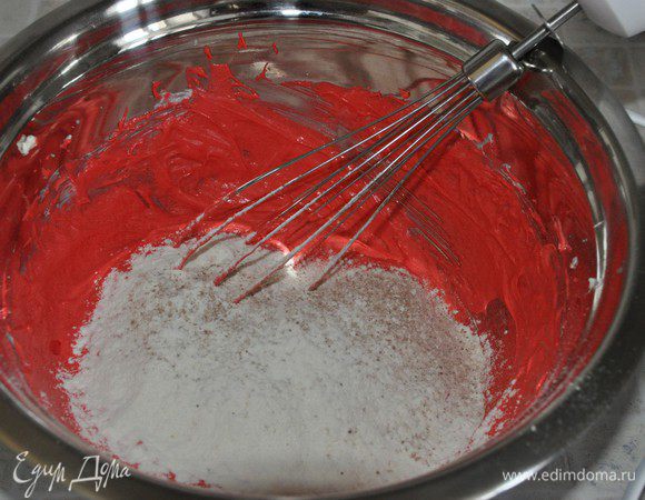 В отдельной миске смешать муку, какао-порошок и соду. Частями просеять их к тесту, каждый раз размешивать лопаткой только до объединения. Включить разогреваться духовку до 180°С, противень застелить пергаментом (у меня тефлоновый лист).