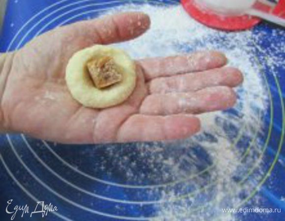 Из теста сделать маленькую лепёшечку (руки в муке), в середину положить кусочек конфетки.