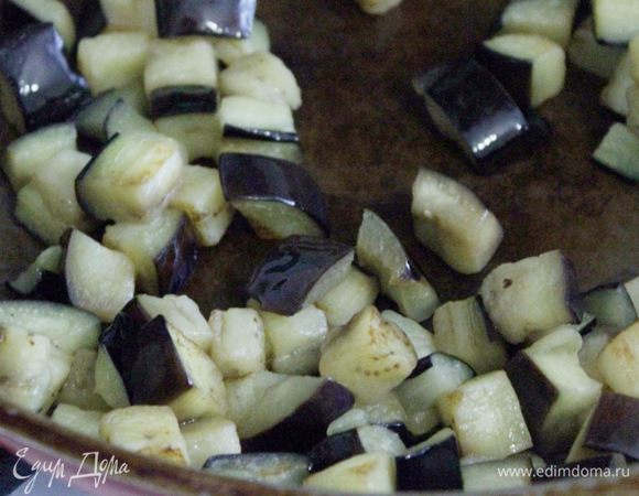 Баклажан порезать кубиками, посыпать солью и оставить минут на 10. Промыть баклажаны, откинуть на дуршлаг, чтобы стекла жидкость. Затем обжарить на оливковом масле.