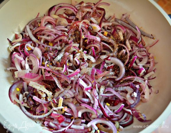 Через 2-3 минуты чеснок вынуть (он нам больше не пригодится), огонь уменьшить, выложить лук, посыпать его сухими прованскими травами. Потомить лук на маленьком огне около получаса, время от времени помешивая.