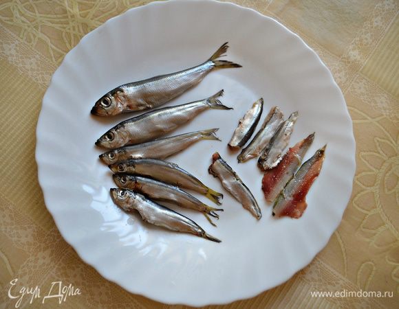 Очистить кильку, вынуть хребет с косточками, удалить голову и хвост,  разобрать на 2 филейные части.