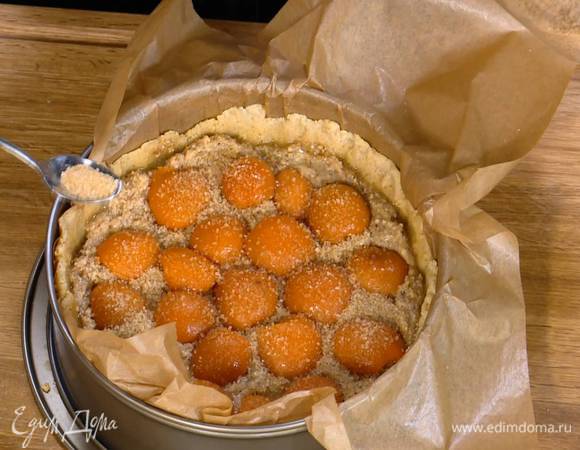 Посыпать абрикосы оставшимся сахаром и выпекать тарт в разогретой духовке 30 минут.