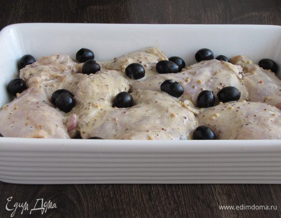 Добавить в миску с кроликом горчицу, перемешать и оставить еще на полчаса. Остроту можно регулировать по вкусу, если горчица не слишком острая, можно взять ее больше. Выложить кусочки маринованного кролика на лук. Добавить маслины. Запекать в духовке при 180-200°C около часа.