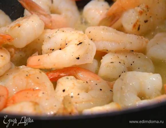 Когда креветки будут практически готовы, влить в сковороду вино, посыпать щепоткой перца чили, все перемешать и дать алкоголю выпариться.