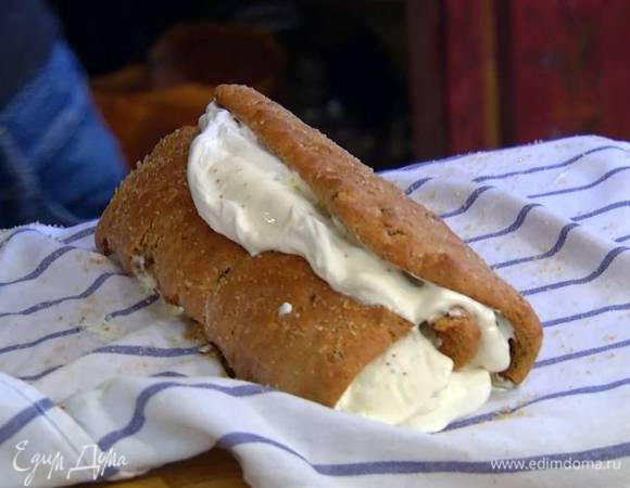 Развернуть корж, промазать его инжирным вареньем, сверху распределить взбитые сливки, снова свернуть в рулет и посыпать сахарной пудрой.