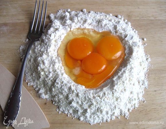 Сделать "колодец" из муки, в центр поместить оливковое масло, яйца, белок, желток. 