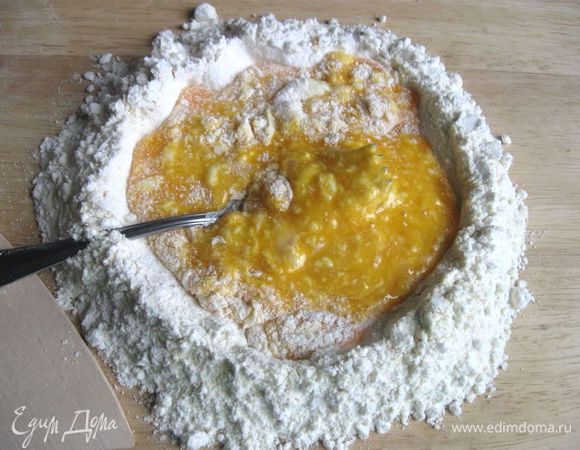 Вилкой начать перемешивать осторожно от центра, захватывая небольшое количество муки, стараясь не разрушить "колодец" на первой стадии смешивания муки и яиц. 
