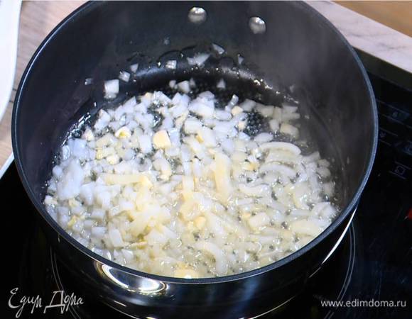 Разогреть в сковороде оливковое и сливочное масло и обжарить лук и чеснок до прозрачности.