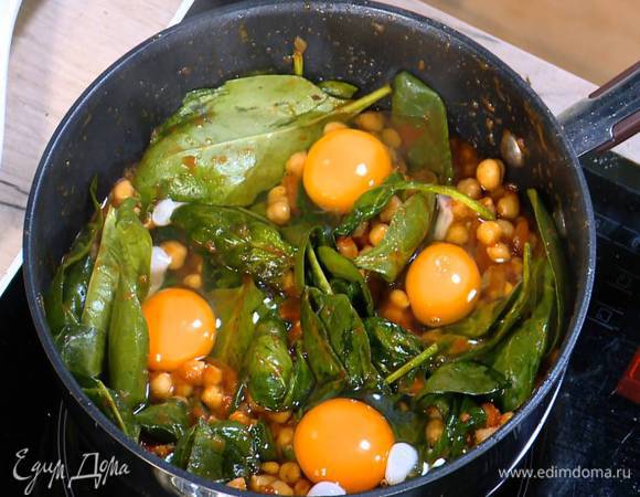 Яйца разбить на шпинат с нутом, накрыть сковороду крышкой и обжаривать все до готовности яиц.