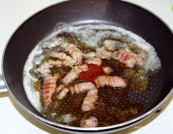 Бекон нарезать на мелкие кусочки, подрумянить с 30 г сливочного масла.