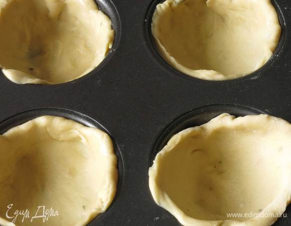 Раскатываем тесто, вырезаем кружки, выкладываем в формы для маффинов.