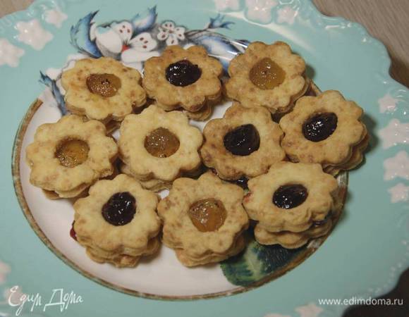 Печенье без отверстий смазать джемом и накрыть сверху печеньицами с отверстиями.