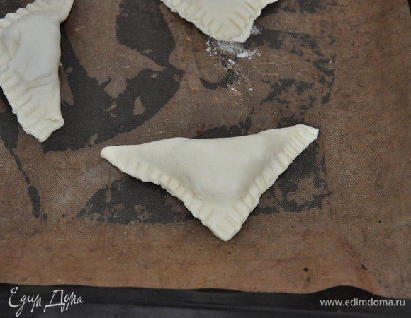 Свернуть квадрат в треугольник, закрепить и плотно прижать вилкой края. 
Выпекать в разогретой до 200°C духовке около 15-18 минут до золотистого цвета — следите по своей духовке. 
