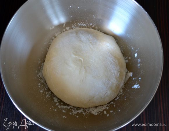 Просеять в полученную смесь муку и замесить мягкое тесто. Переложить в миску, слегка припыленную мукой, накрыть полотенцем и поставить в спокойное тёплое место минут на 45.