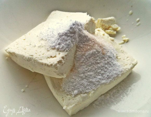 В 2 пачки творога по 180 г всыпать сахар и ваниль.