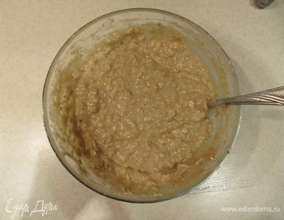 Добавить просеянную с разрыхлителем муку и овсяные хлопья. Все перемешать.