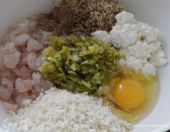Рыбное филе нарезать не очень крупным кубиком, добавить творог, хлебные крошки, молотые грецкие орехи, яйцо и обжаренный на растительном масле лук-порей. Добавить соль и молотый перец по вкусу. По желанию можно добавить зелень.