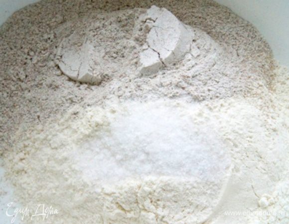 Смешать оба вида муки, соль, щепотку сухих дрожжей. 
