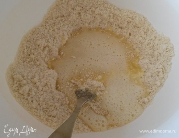 Выливаем яичную смесь к мучной. Аккуратно перемешиваем вилкой. А потом и руками замешиваем тесто. 